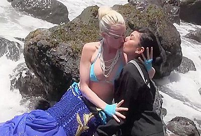 One Girl Dressed As A Mermaid Was Kissing Another Lesbian Brunette Girl By The Sea